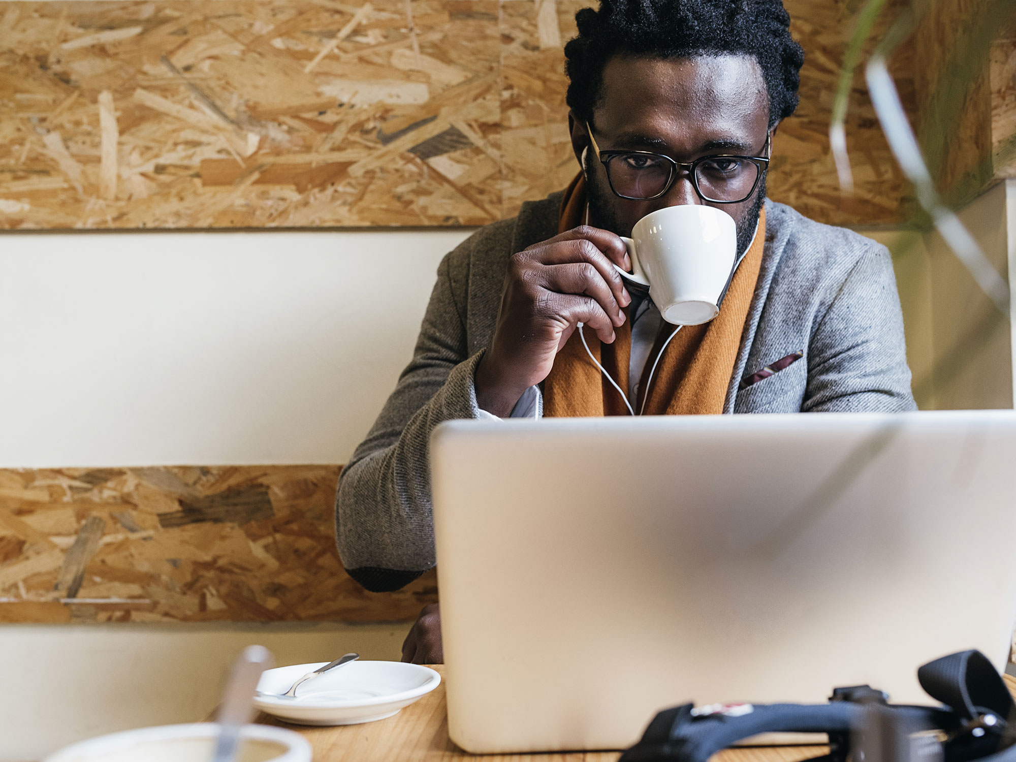 Man sipping espresso while on his laptop